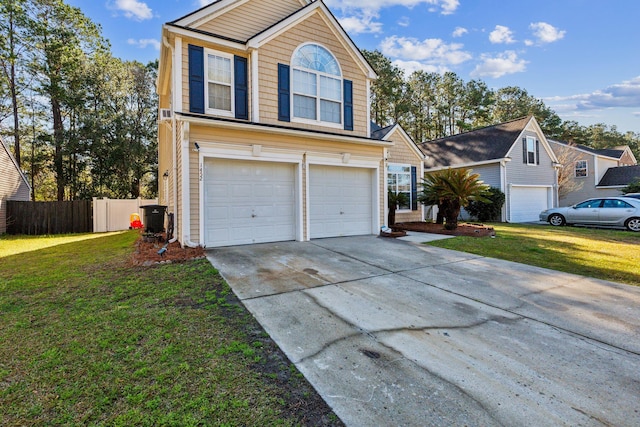 traditional home featuring an attached garage, driveway, a front yard, and fence