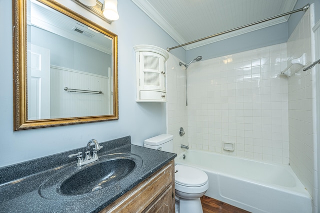 full bathroom featuring tiled shower / bath, hardwood / wood-style flooring, toilet, ornamental molding, and vanity