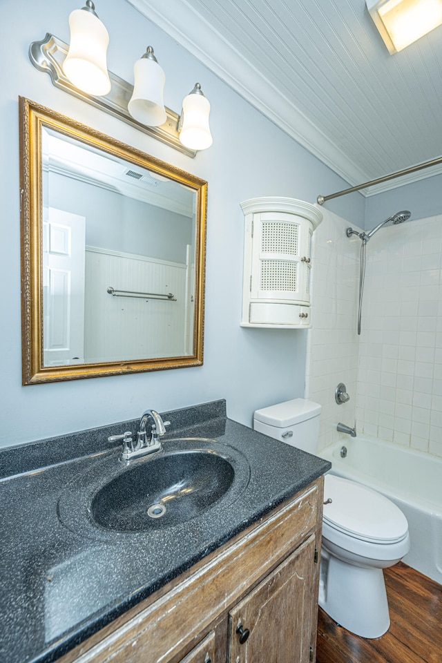 full bathroom featuring wood-type flooring, toilet, ornamental molding, vanity, and tiled shower / bath combo