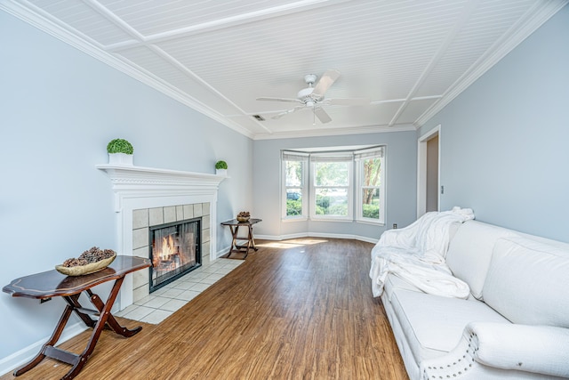 living room featuring light hardwood / wood-style flooring, ornamental molding, a fireplace, and ceiling fan