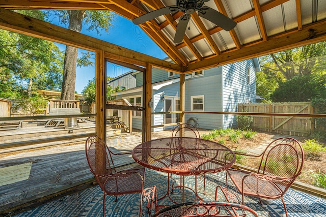 sunroom with ceiling fan, a wealth of natural light, and vaulted ceiling with beams