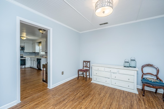 living area with sink, wood-type flooring, and ornamental molding