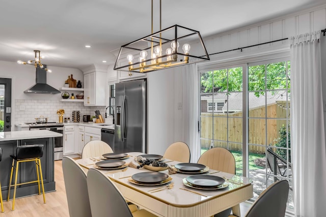 dining room featuring a chandelier, light wood-style flooring, and recessed lighting