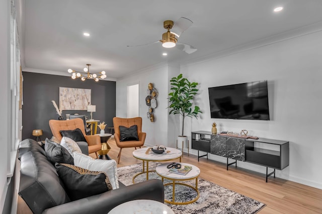 living area featuring ornamental molding, a chandelier, wood finished floors, baseboards, and ceiling fan