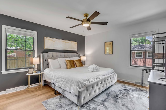 bedroom with wood finished floors, baseboards, and a ceiling fan