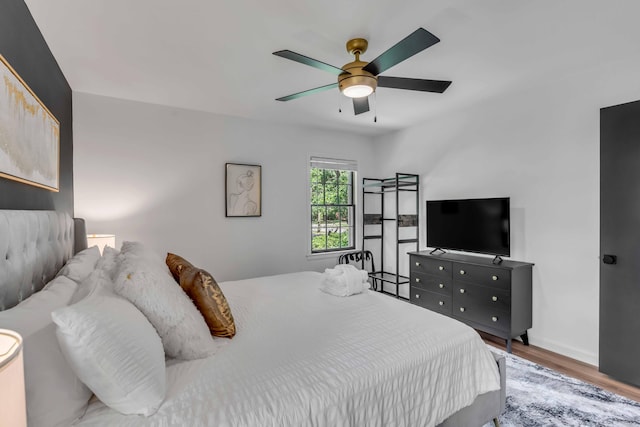 bedroom with wood finished floors, ceiling fan, and baseboards