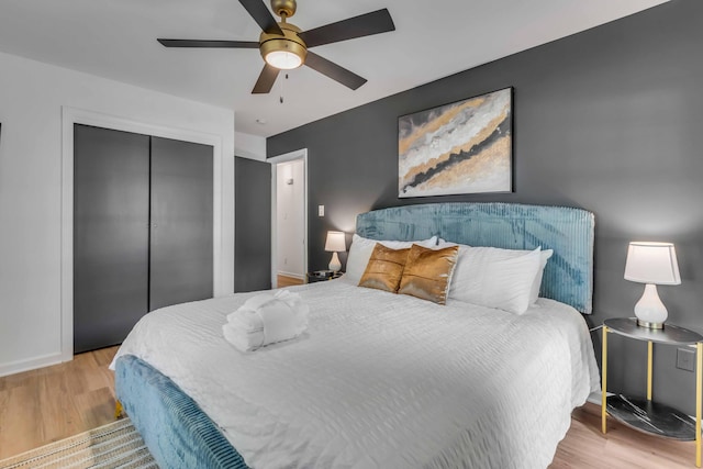 bedroom featuring wood finished floors, a closet, baseboards, and a ceiling fan