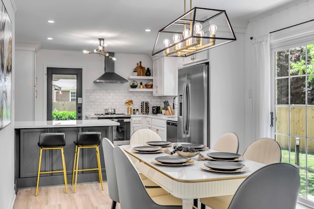dining area with a chandelier, light wood-style floors, and recessed lighting