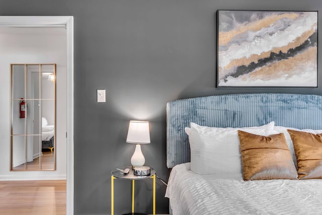 bedroom with wood finished floors and baseboards