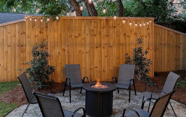 view of patio featuring an outdoor fire pit and fence