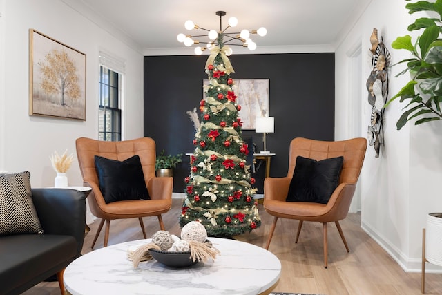 sitting room featuring a chandelier, wood finished floors, crown molding, and baseboards