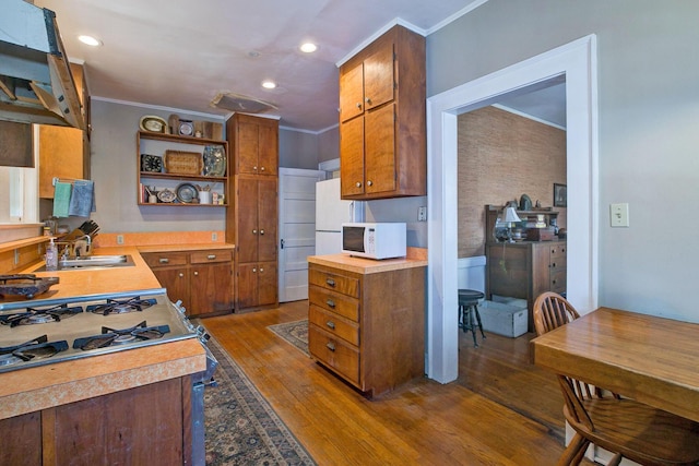 kitchen with white microwave, a sink, open shelves, ornamental molding, and dark wood-style flooring