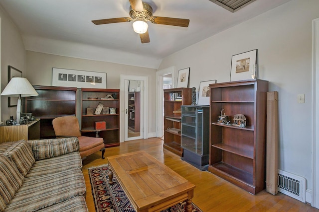 living area with visible vents, baseboards, a ceiling fan, and wood finished floors