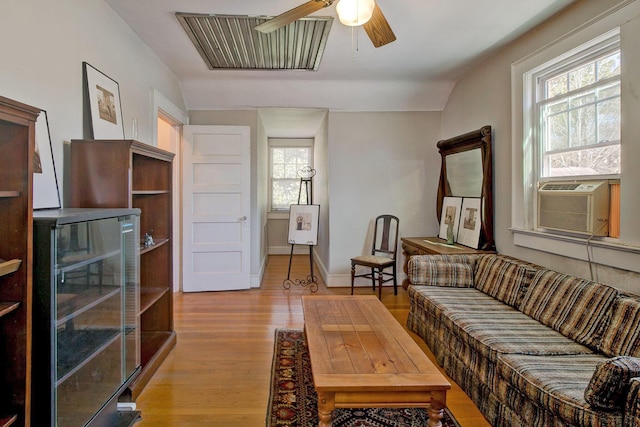 living area featuring visible vents, beverage cooler, a ceiling fan, wood finished floors, and baseboards