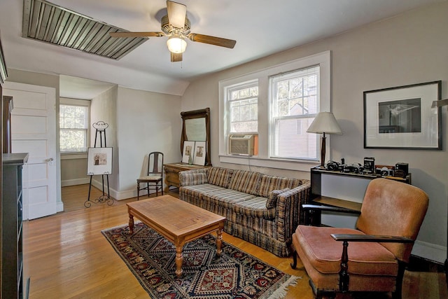 living room featuring light wood finished floors, cooling unit, baseboards, and ceiling fan