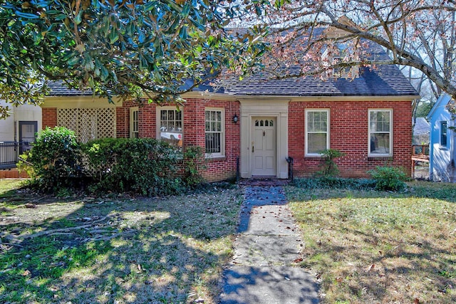 view of front of home featuring brick siding and a front yard