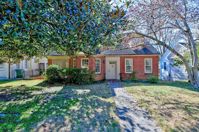 view of front of home with brick siding and a front lawn