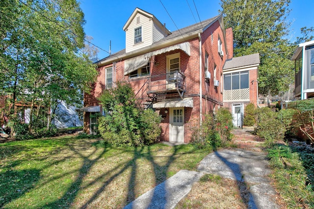 view of front facade with a front lawn and brick siding