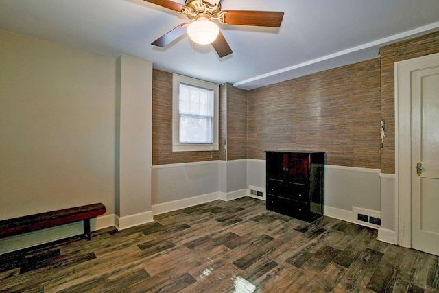 miscellaneous room with ceiling fan, visible vents, dark wood finished floors, and wainscoting