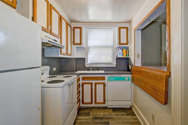 kitchen with white appliances, dark wood-style flooring, under cabinet range hood, and a sink