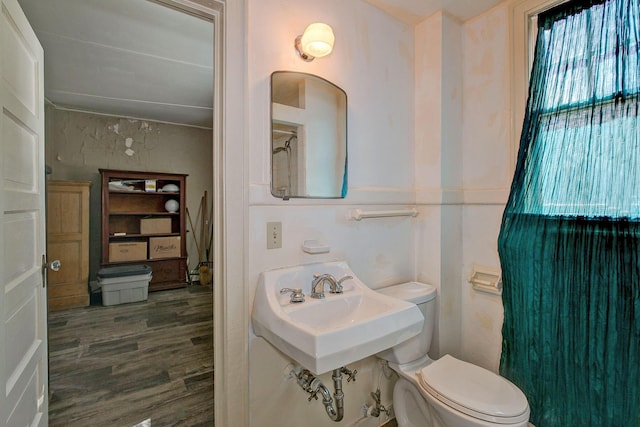 bathroom featuring toilet, wood finished floors, and a shower