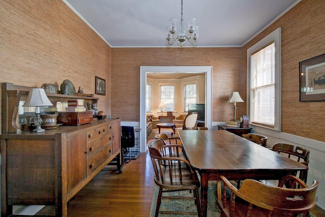 dining room with plenty of natural light, crown molding, an inviting chandelier, and wood finished floors