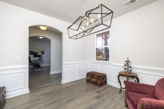 409 Pine Lake Ct, Manning, SC 29102 - living area with wainscoting, wood finished floors, arched walkways, a chandelier, and a decorative wall