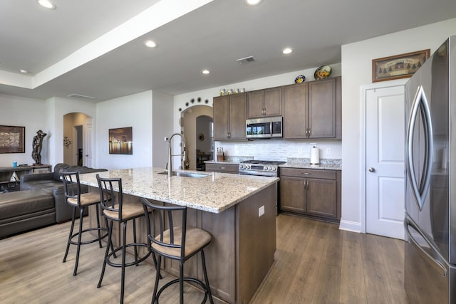 409 Pine Lake Ct, Manning, SC 29102 - kitchen featuring stainless steel appliances, arched walkways, a sink, dark wood-style floors, and recessed lighting
