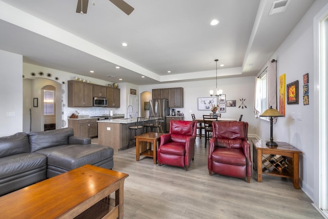 409 Pine Lake Ct, Manning, SC 29102 - living room featuring light wood-type flooring, ceiling fan, a tray ceiling, recessed lighting, and arched walkways