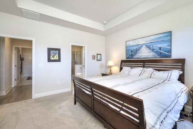 409 Pine Lake Ct, Manning, SC 29102 - bedroom featuring light colored carpet, baseboards, ensuite bathroom, and a raised ceiling