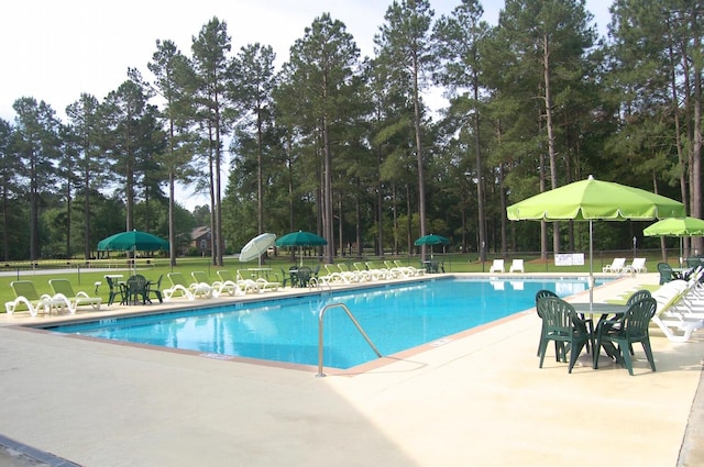 409 Pine Lake Ct, Manning, SC 29102 - community pool featuring a patio area and view of scattered trees