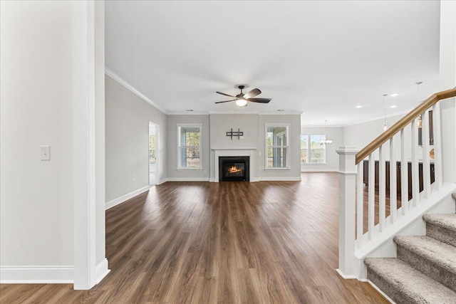 unfurnished living room featuring crown molding, ceiling fan, and dark wood-type flooring