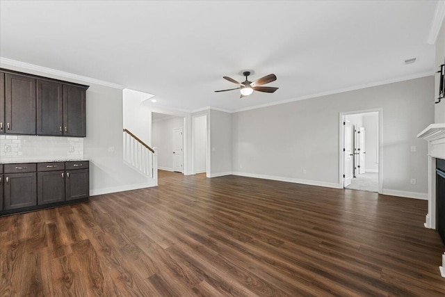 unfurnished living room featuring ceiling fan, ornamental molding, and dark wood-type flooring