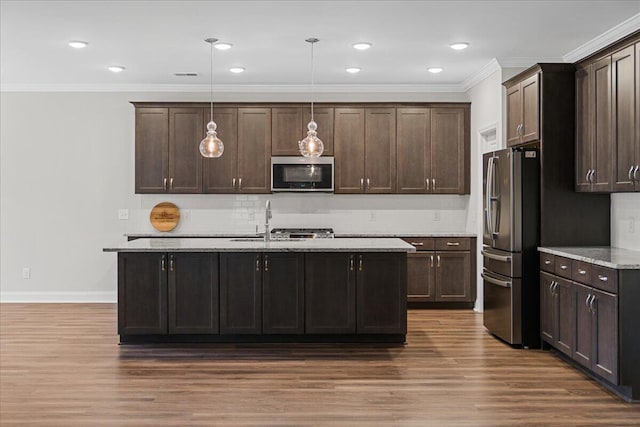 kitchen featuring decorative light fixtures, dark brown cabinetry, stainless steel appliances, and dark wood-type flooring