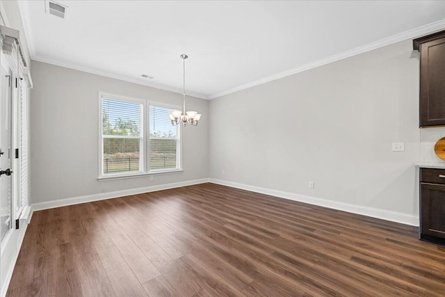 unfurnished dining area featuring dark hardwood / wood-style floors, an inviting chandelier, and ornamental molding