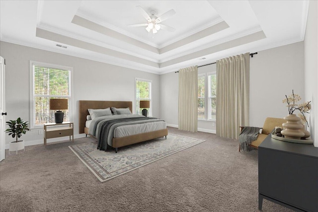 carpeted bedroom featuring ceiling fan, ornamental molding, and a tray ceiling