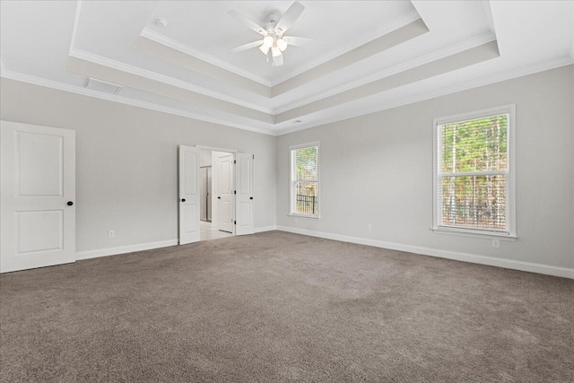 carpeted empty room featuring a raised ceiling, crown molding, and ceiling fan