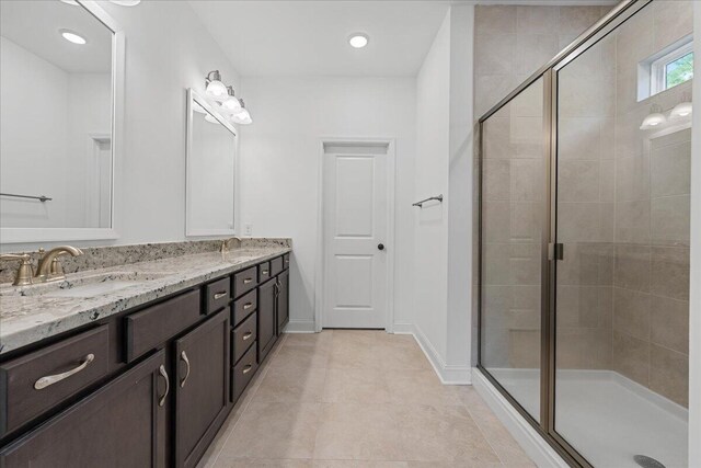 bathroom featuring tile patterned flooring, vanity, and a shower with shower door