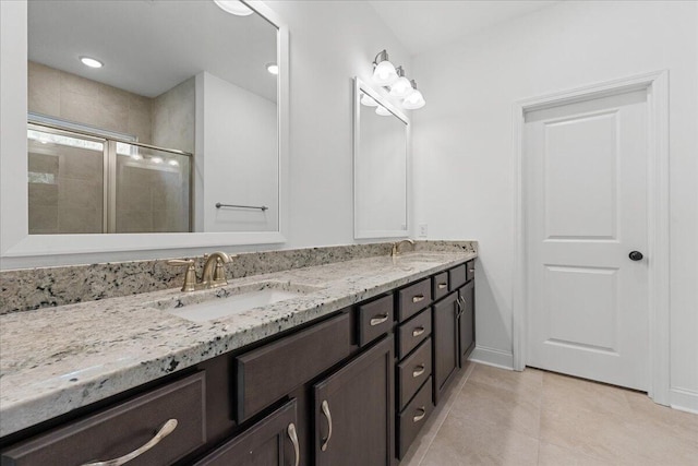 bathroom with tile patterned flooring, vanity, and a shower with door