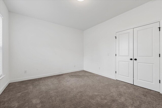 unfurnished bedroom featuring carpet flooring and a closet