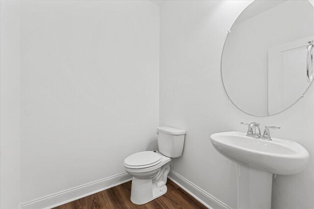 bathroom featuring sink, wood-type flooring, and toilet