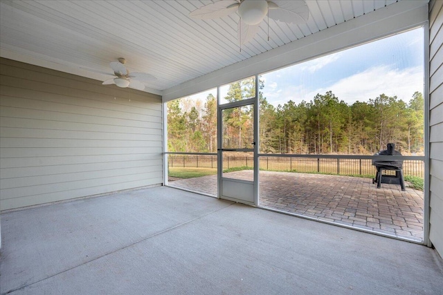 unfurnished sunroom with ceiling fan