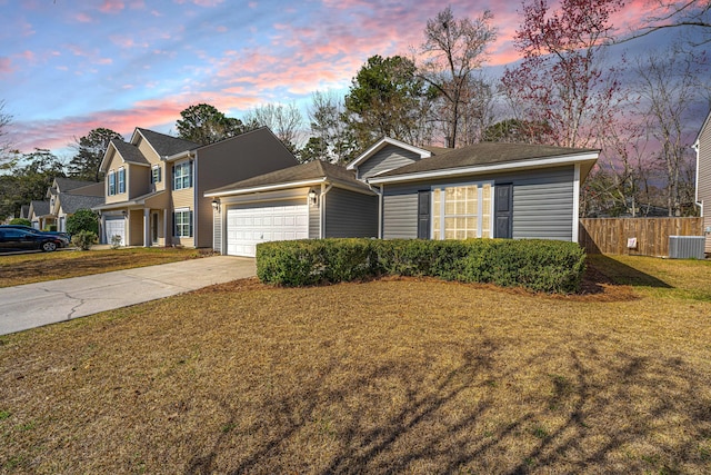 traditional home featuring a front lawn, driveway, central AC, fence, and an attached garage