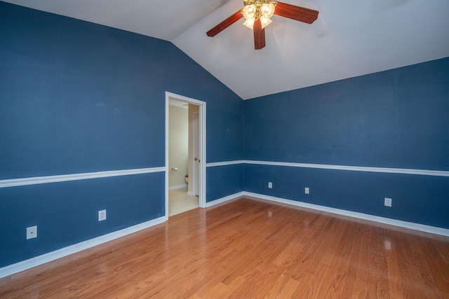 empty room featuring baseboards, wood finished floors, a ceiling fan, and vaulted ceiling