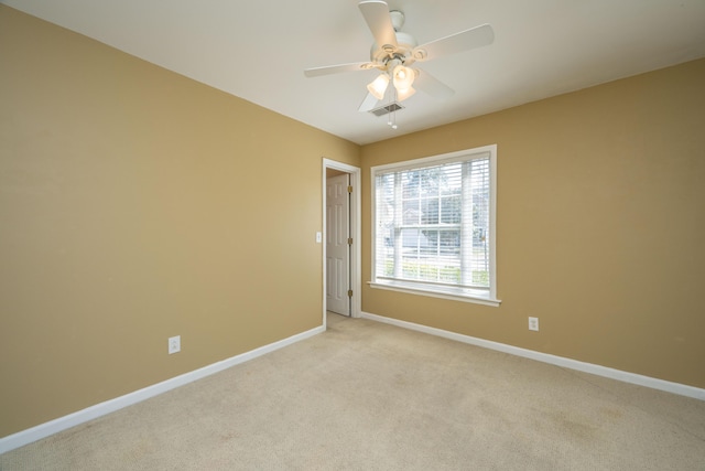 empty room with visible vents, baseboards, light colored carpet, and a ceiling fan