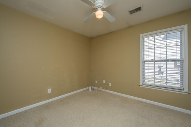 empty room with visible vents, baseboards, carpet, and a ceiling fan