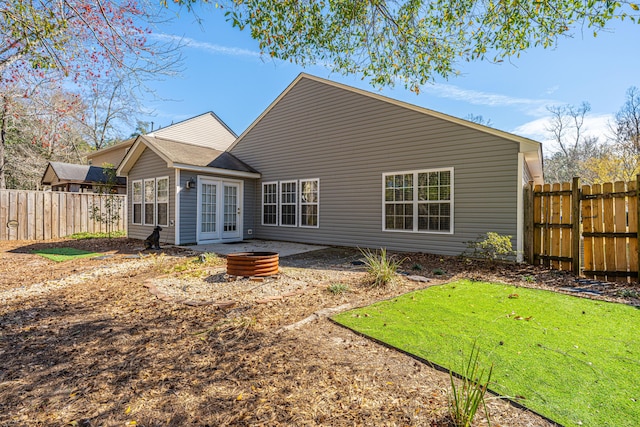 back of house featuring french doors, a patio, a fenced backyard, and an outdoor fire pit