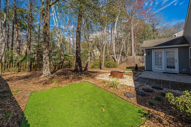 view of yard featuring a patio, an outdoor fire pit, and fence