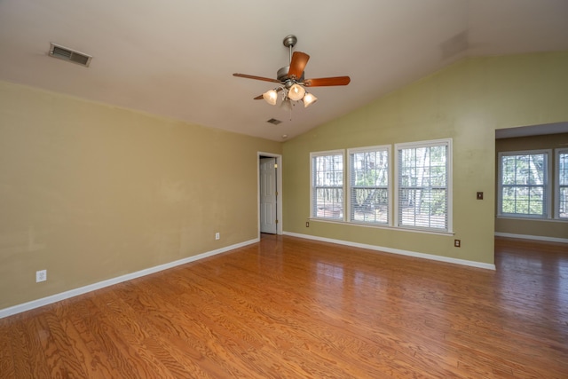 unfurnished room featuring visible vents, wood finished floors, baseboards, lofted ceiling, and ceiling fan