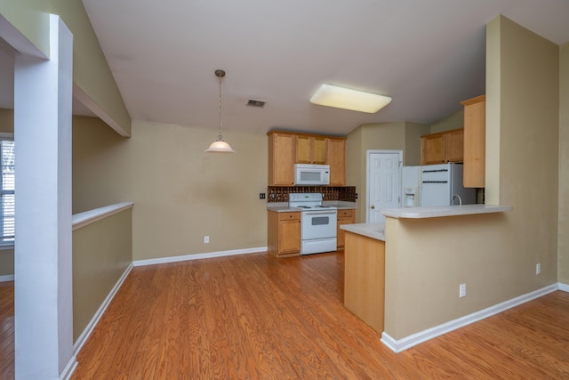 kitchen with white appliances, light countertops, visible vents, and light wood finished floors